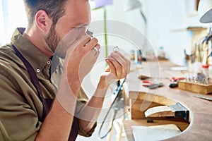 Young Jeweler Appraising Ring in Shop