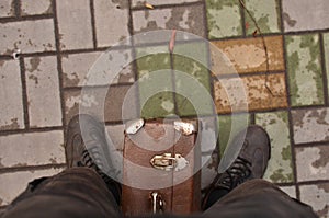 Side view portrait of male traveler standing by the street with suitcase