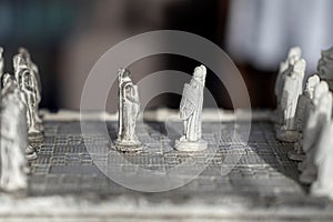 A side view portrait of two pawns facing eachother in the beginning of a strategic game of chess. The duel will be fought on a