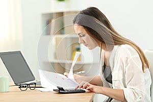 Woman calculating expenses at home photo