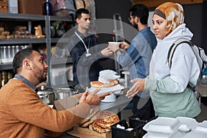 Middle Eastern Woman Receiving Food at Refugee Help Center