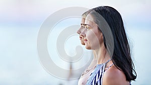 Side-view portraits of mother and teenage daughter against sea background