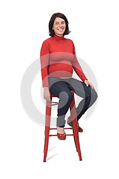 Side view of a pregnant woman sitting on a stool on white background