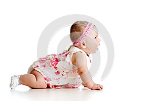 Side view of pretty baby girl crawling on floor