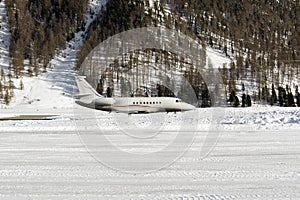 Side view of a private jet taking off in the snowy alps in St Moritz Switzerland