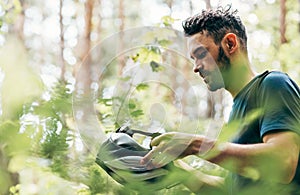 Side view of professional cyclist takes off his helmet after cycling in the mountain. Male athlete preparing before the riding the