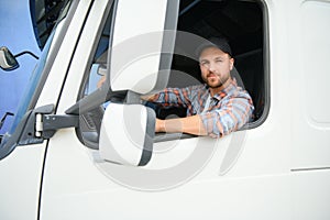 Side view of professional driver behind the wheel in truck& x27;s cabin.