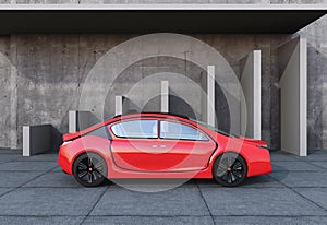 Side view of red autonomous car in front of geometric object background