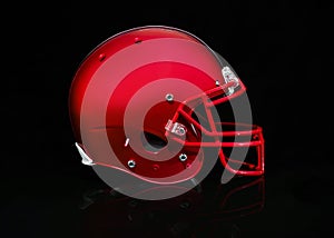 Side view of a red football helmet on a black background