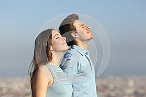 Relaxed couple breathing fresh air with urban background photo