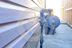 Side view of a residential urban natural gas meter, measuring gas consumption, outside house gas meter