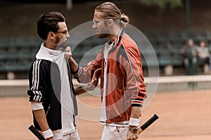 side view of retro styled tennis players having conflict