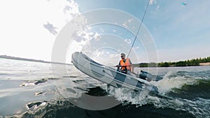 Side view of a rubber boat with a man sailing along the river