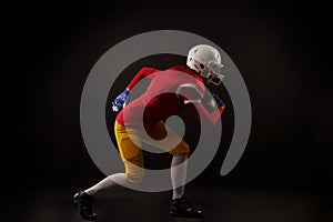 Side view of running girl in white helmet with rugby ball in her hand in studio