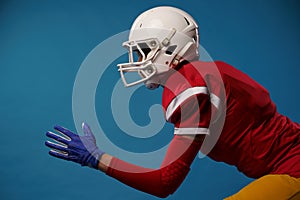 Side view of running woman of american football player on blue background