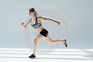 Side view of running woman in sportive clothing
