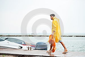 Side view of a sailor holding life vest at pier