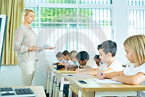 Side view of schoolkids group working on lecture in classroom