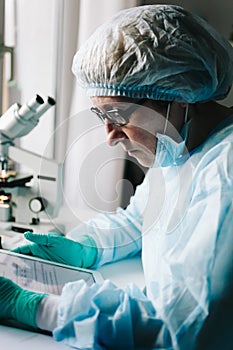 Side view of scientist working on tablet