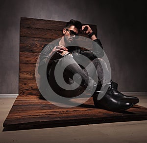 Side view of a seated fashion man in leather jacket