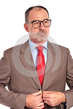 Side view of a senior businessman buttoning his suit