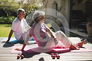 Side view of senior couple exercising together at porch