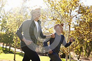 Side View Of Senior Couple Power Walking Through Park