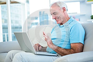 Side view of senior man using laptop