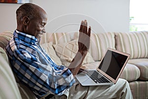 Side view of senior man video conferencing at home