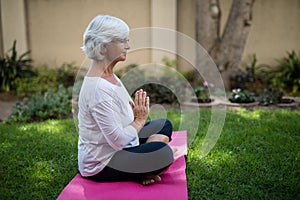 Side view of senior woman meditating in prayer position