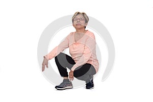 Side view of a senior woman squatting on white backgrond