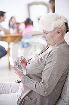 Side view of senior woman using digital tablet at home