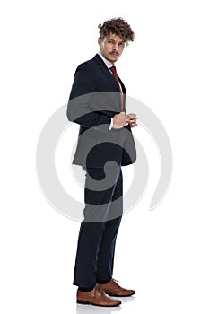 Side view of serious businessman adjusting his jacket