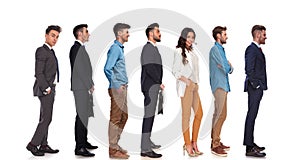 Side view of seven different people standing in line