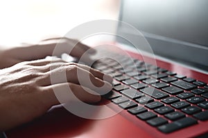 Side view shot of man`s hands busy working on his laptop sitting at wooden table. work and study concept