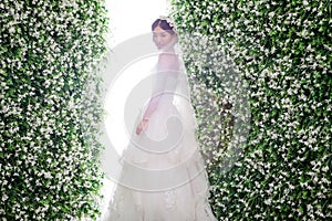 Side view of shy bride standing amidst flower decorations