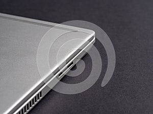 Side view of a silver closed laptop on a dark background