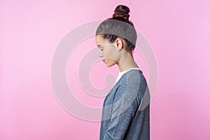 Side view of sleepy brunette teenage girl standing dreaming or imagining with closed eyes.  on pink background