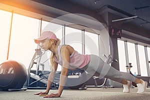 Side view of a slim fitnes young blonde girl doing planking exer