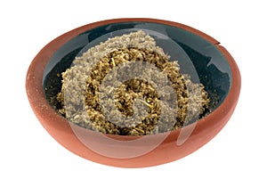 Side view of a small portion of crushed sage leaf in a bowl isolated on a white background