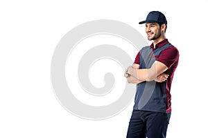 side view of smiling delivery man in cap with arms crossed