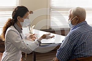 Side view smiling female doctor wearing mask consulting old man