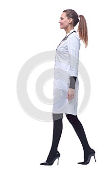 Side view. smiling female paramedic striding forward.