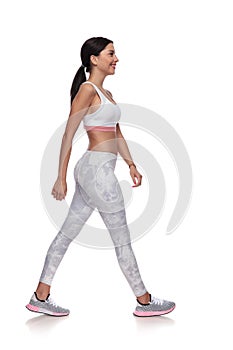 Side view of smiling fitness woman walking