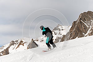 side view on snowboarder riding freeride on powder snow down the slope