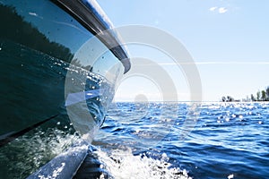 Side view Speeding fishing motor boat with drops of water. Blue ocean sea water wave reflections with fast fishing yacht. Motor bo