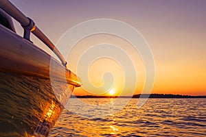 Side view Speeding fishing motor boat with drops of water. Blue ocean sea water wave reflections at the sunset. Motor boat in the