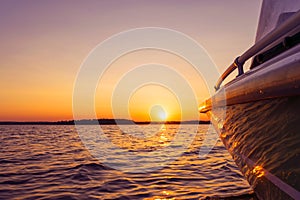 Side view Speeding fishing motor boat with drops of water. Blue ocean sea water wave reflections at the sunset. Motor boat in the