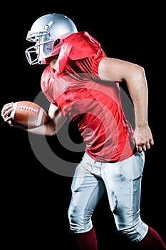 Side view of sportsman running while playing American football