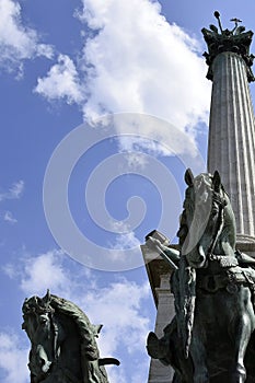 Side view on statue horses of  the chieftains of the Magyars against a blue sky with clouds. Fragment of the Millennium Monument